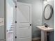 Charming powder room with a pedestal sink, round mirror, and light blue walls at 10459 Trellis Lane (Lot 27), Hampton, GA 30228