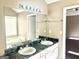 Bathroom featuring double sinks, large mirror, vanity lighting, and tile counters at 3497 Thornewoode Pointe, Decatur, GA 30034