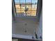 Bright bathtub with polished chrome faucet and view of the backyard through a large window at 10467 Tara Beach Cir, Jonesboro, GA 30238