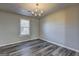 Bright dining room featuring gray wood floors, a chandelier, and a large window at 5495 Reynolds Rd, Morrow, GA 30260