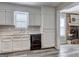 Well-lit kitchen featuring modern appliances and white cabinets with a view to the living room at 5495 Reynolds Rd, Morrow, GA 30260