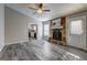 Inviting living room featuring a stone fireplace, ceiling fan, and stylish gray wood floors at 5495 Reynolds Rd, Morrow, GA 30260