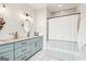 Bathroom featuring blue vanity with granite countertop, oval mirror, and tub with shower at 987 Lena Nw St, Atlanta, GA 30314