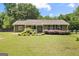 Charming single-story home with a well-manicured lawn, flowerbeds, and a cozy front porch at 888 Laney Rd, Locust Grove, GA 30248
