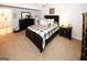 This main bedroom offers neutral carpeting, dark furnishings, and an abundance of natural light at 888 Laney Rd, Locust Grove, GA 30248
