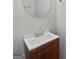 Bathroom with a round mirror, a wooden cabinet, and a white countertop sink at 11403 South Grove Dr, Hampton, GA 30228