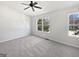 Bright bedroom featuring soft carpet, neutral walls, a ceiling fan and two large windows at 11403 South Grove Dr, Hampton, GA 30228