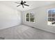 Bright bedroom featuring soft carpet, a ceiling fan, and two large windows providing plenty of natural light at 11403 South Grove Dr, Hampton, GA 30228