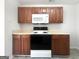 Well-lit kitchen with a black electric range, built-in microwave, and dark cabinets with light countertops for meal preparation at 11403 South Grove Dr, Hampton, GA 30228