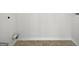 Unfinished laundry room includes hook-ups for washer/dryer, white walls, neutral baseboards and plank flooring at 11403 South Grove Dr, Hampton, GA 30228