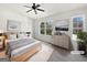 Staged main bedroom features a ceiling fan, large windows and decor at 11403 South Grove Dr, Hampton, GA 30228