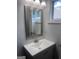 Bathroom vanity with a framed mirror, white sink, and window at 1066 Ashby Sw Grv, Atlanta, GA 30314