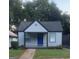 Charming one-story home with a blue front door and well manicured lawn at 1066 Ashby Sw Grv, Atlanta, GA 30314