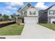 Charming two-story home featuring stone accents, a two-car garage, and a well-manicured lawn under a sunny sky at 11192 Cornerstone Way, Hampton, GA 30228