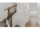 Hallway featuring wood flooring, white trim, and stairs with wood and black metal railings at 11192 Cornerstone Way, Hampton, GA 30228
