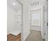 Hallway includes a laundry room, neutral carpet, white trim and walls, natural light and closet at 11192 Cornerstone Way, Hampton, GA 30228