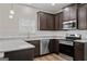 Modern kitchen with dark wood cabinetry, granite countertops, stainless steel appliances, and subway tile backsplash at 11192 Cornerstone Way, Hampton, GA 30228