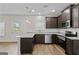 Modern kitchen features dark wood cabinets, stainless steel appliances, granite countertops and hardwood floors at 11192 Cornerstone Way, Hampton, GA 30228