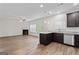 Open concept kitchen features granite countertops, stainless appliances, dark wood cabinets, hardwood floors and fireplace at 11192 Cornerstone Way, Hampton, GA 30228