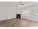 Cozy living room with hardwood floors, a corner fireplace, and plenty of natural light from the window at 11192 Cornerstone Way, Hampton, GA 30228