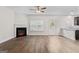 Bright living room with hardwood floors, a cozy fireplace, and an open layout leading to the kitchen at 11192 Cornerstone Way, Hampton, GA 30228