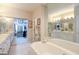 Luxurious bathroom with a soaking tub, double vanity, and walk-in closet access at 168 Maple Grove Ter, Peachtree City, GA 30269