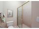 Cozy bathroom featuring a toilet, shower stall with glass door, and decorative wall mirror at 168 Maple Grove Ter, Peachtree City, GA 30269