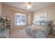 Comfortable bedroom with a floral bedspread, ceiling fan, and a bright window view at 168 Maple Grove Ter, Peachtree City, GA 30269