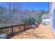 View of a wooden deck with a grill and outdoor seating, overlooking a wooded backyard at 168 Maple Grove Ter, Peachtree City, GA 30269