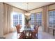 Sunlit dining room with glass-top table, wicker chairs, and large windows at 168 Maple Grove Ter, Peachtree City, GA 30269