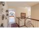 Upstairs hallway with hardwood railing, patterned rug, multiple clocks, and doorway view to another room at 168 Maple Grove Ter, Peachtree City, GA 30269