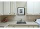 Laundry area with ample storage, a sink, and modern white appliances at 168 Maple Grove Ter, Peachtree City, GA 30269