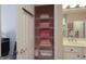 Bathroom linen closet with shelving stocked with neatly folded towels, visible next to a sink and mirror at 168 Maple Grove Ter, Peachtree City, GA 30269