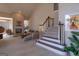 Spacious living room with vaulted ceilings, a fireplace, neutral carpeting, and a staircase to the upper level at 168 Maple Grove Ter, Peachtree City, GA 30269
