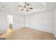 Bedroom with a ceiling fan, neutral carpeting and view into the ensuite bathroom at 521 Cody Ln, Mcdonough, GA 30252