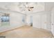 Spacious bedroom featuring a trey ceiling, fan, neutral carpeting and ensuite access at 521 Cody Ln, Mcdonough, GA 30252
