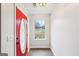 Bright entryway features a red front door, neutral walls, and a window providing natural light at 521 Cody Ln, Mcdonough, GA 30252