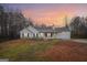 Exterior of a home with a sunset sky, featuring a well-maintained front yard and a two-car garage at 521 Cody Ln, Mcdonough, GA 30252