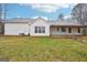 The back of the home has white siding and a covered patio and overlooks the green lawn at 521 Cody Ln, Mcdonough, GA 30252