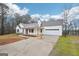 Charming single-story home with white siding, red front door, covered porch and attached garage at 521 Cody Ln, Mcdonough, GA 30252