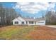 Charming single-story home featuring white siding, black shutters, attached garage, and spacious front yard at 521 Cody Ln, Mcdonough, GA 30252