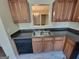Modern kitchen with stainless steel sink, sleek black appliances, and wood cabinets at 3535 Waldrop Trl, Decatur, GA 30034