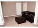 Comfortable living room with a dark leather sofa, ottoman, and neutral carpet at 4286 Rosehall Ct, South Fulton, GA 30349