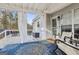 The covered porch features an area rug, curtains and comfortable seating at 1144 Pickets Ridge Dr, Locust Grove, GA 30248