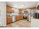 Well-lit kitchen features stainless steel appliances, wood cabinets, and luxury vinyl plank flooring at 1144 Pickets Ridge Dr, Locust Grove, GA 30248