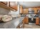 Updated kitchen features wood cabinets, granite countertops, and stainless steel appliances at 1144 Pickets Ridge Dr, Locust Grove, GA 30248
