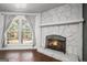 Inviting living room with a stone fireplace, hardwood floors, and a bright window at 4097 Cripple Creek Nw Dr, Kennesaw, GA 30144