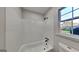 Bright bathroom with a white tub and shower featuring a black shower head and fixtures at 30 Fairfield Dr, Ellenwood, GA 30294