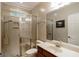 Neutral-toned bathroom featuring a glass-enclosed shower and a vanity with cherry wood cabinet at 2275 Honeysuckle Se Ln, Smyrna, GA 30080