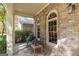 Covered front porch showing brick walls, arched windows, and outdoor seating, creating a relaxing retreat at 2275 Honeysuckle Se Ln, Smyrna, GA 30080